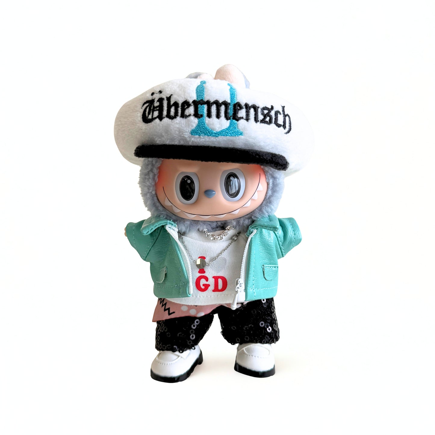 Toy figure wearing a cap with 'Abermensch' text on a white background
